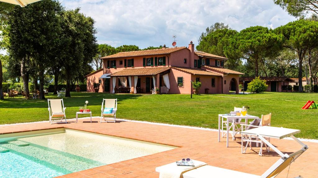 a house with a pool and chairs and a table at Villa Elisa 16, Emma Villas in Fucecchio