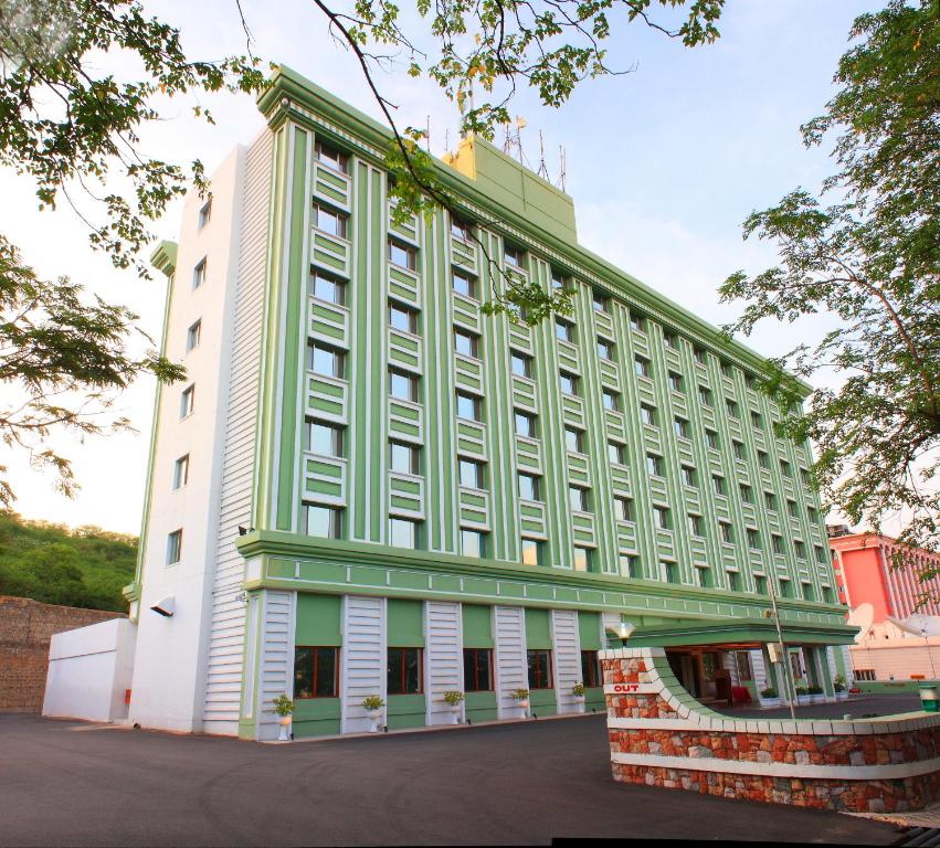 a large building with a green and white at Ramoji Film City- Tara Comfort Hotel in Pedda Ambarpet