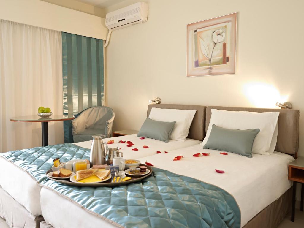 a hotel room with a bed with a tray of food on it at Hotel Galaxias in Rhodes Town