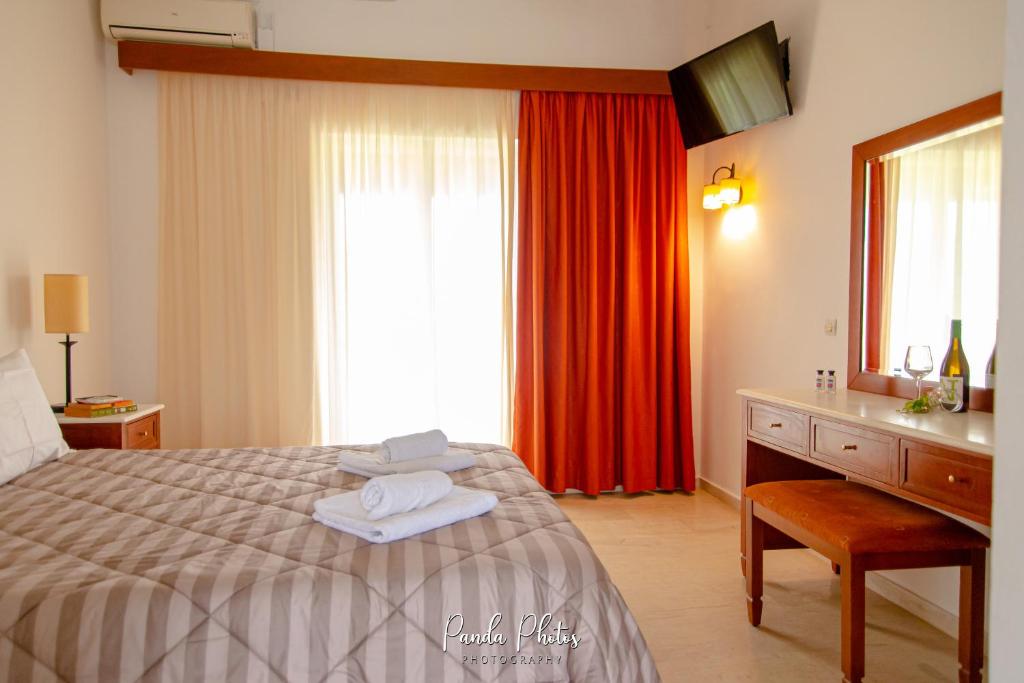 a bedroom with a bed and a dresser and a window at Zante Apts in Laganas