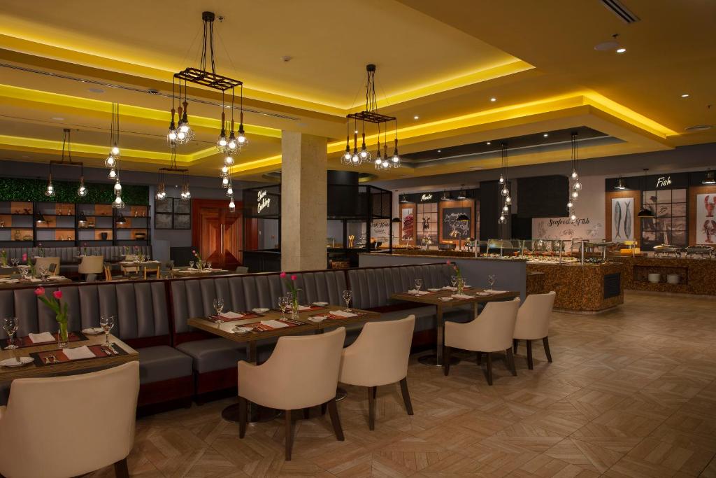 a restaurant with tables and chairs and a bar at Secrets Playa Mujeres Golf & Spa Resort - All Inclusive Adults Only in Cancún