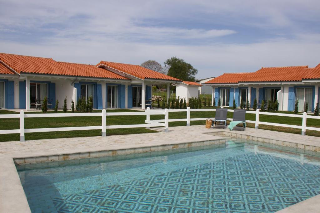a swimming pool in front of some houses at El Pueblín de Ribadesella in Ribadesella