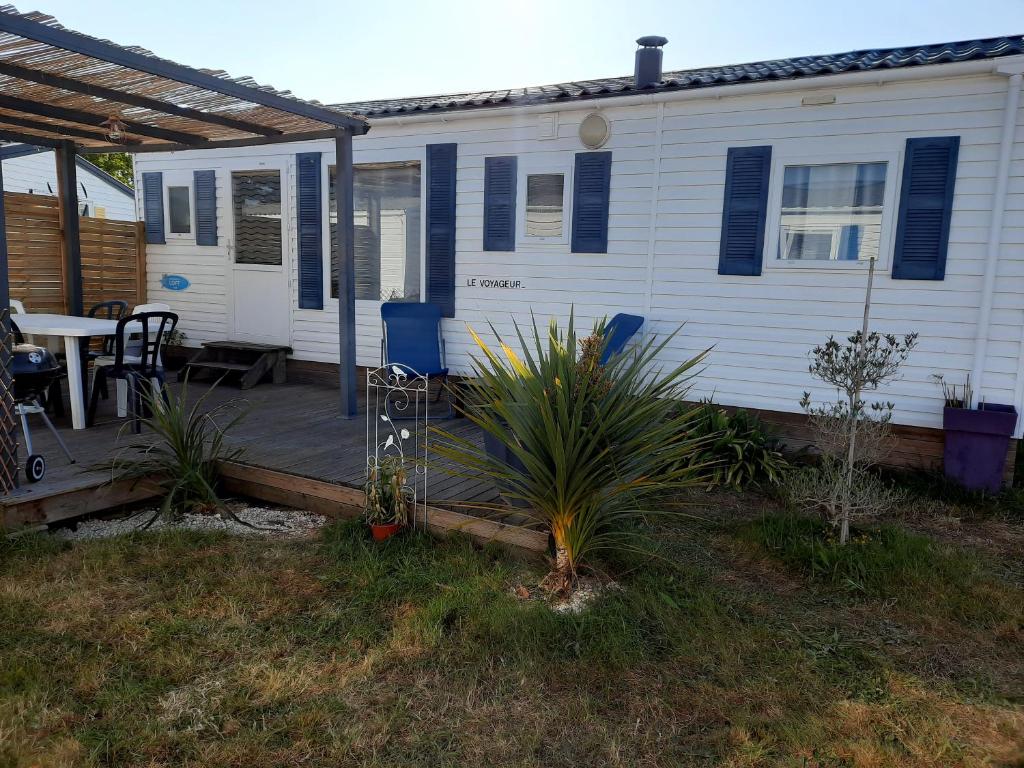 a house with a deck with a table and a patio at Location mobil home in La Baule