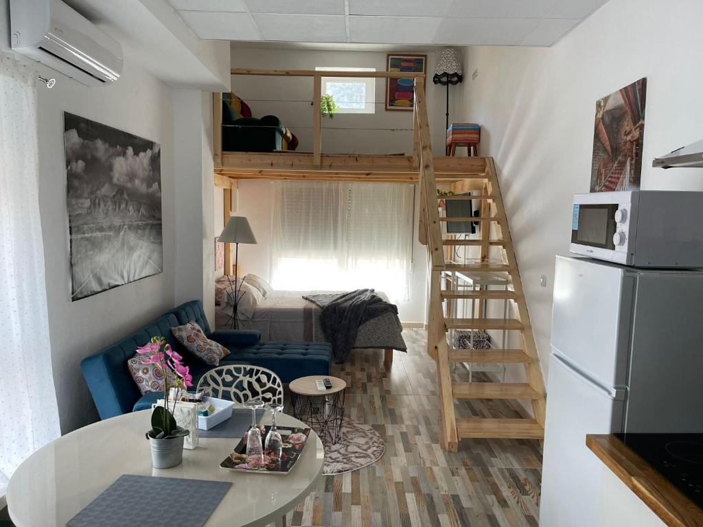 a small living room with a loft bed and a kitchen at Huelintown in Málaga