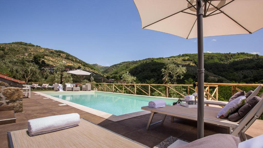 einen Pool mit einem Tisch und einem Sonnenschirm in der Unterkunft VILLA SISSI 10&2, Emma Villas in Massa e Cozzile
