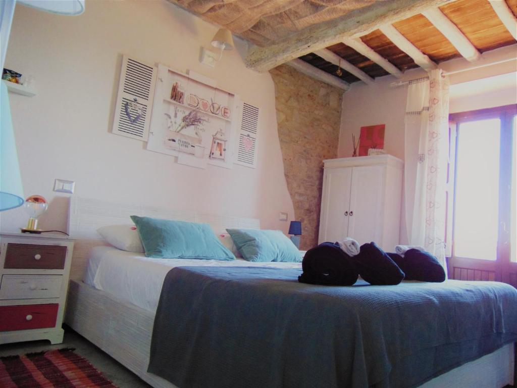 ein Schlafzimmer mit einem großen Bett mit blauer Bettwäsche in der Unterkunft B&B Un posto nel mondo in Siena