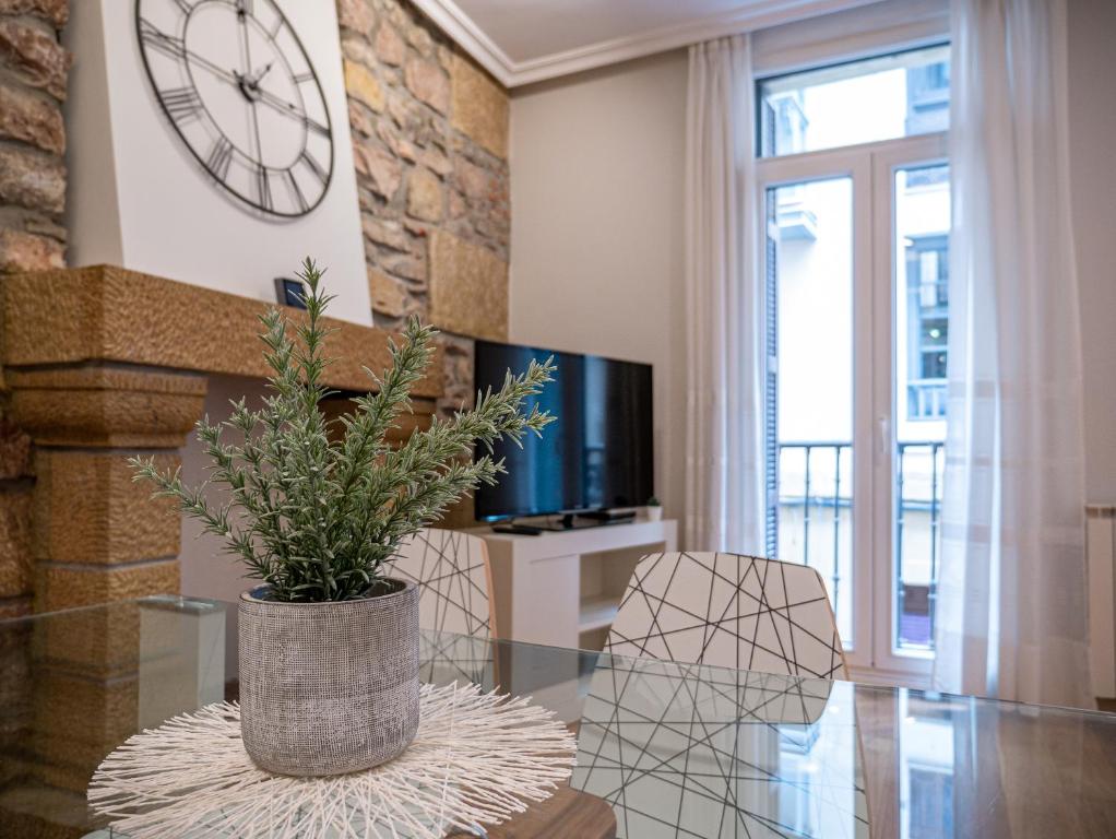 a living room with a table and a clock on the wall at San Telmo Oldtown by DLA in San Sebastián