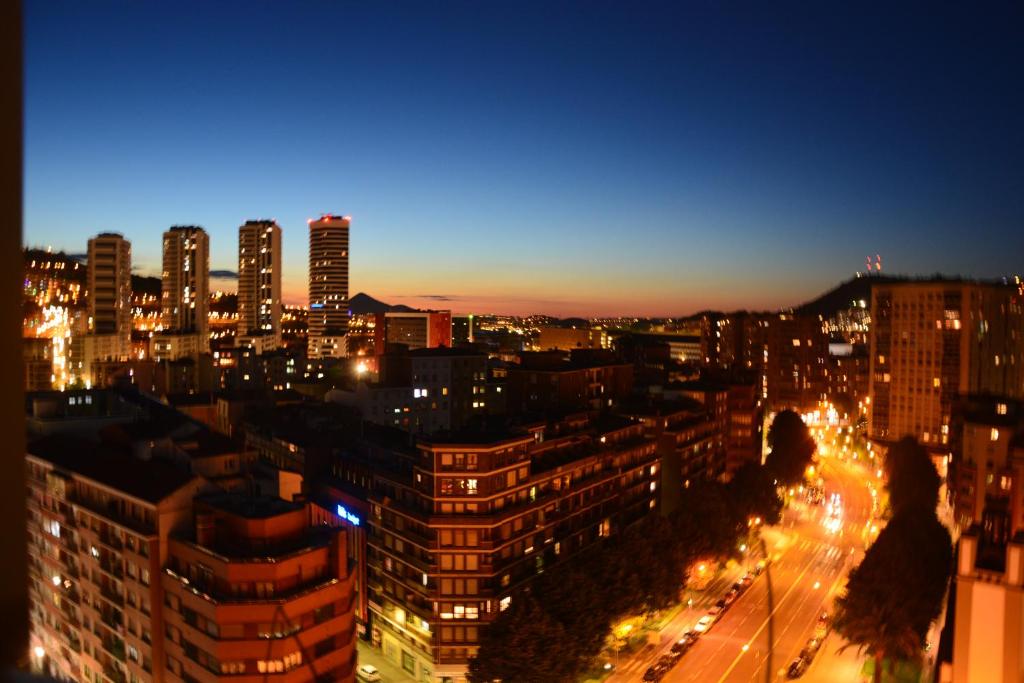 a view of a city at night with lights at Superviews, parking 24h vigilado incluido y Netflix en habitación independiente con baño privado en apartamento particular, Français&English in Bilbao