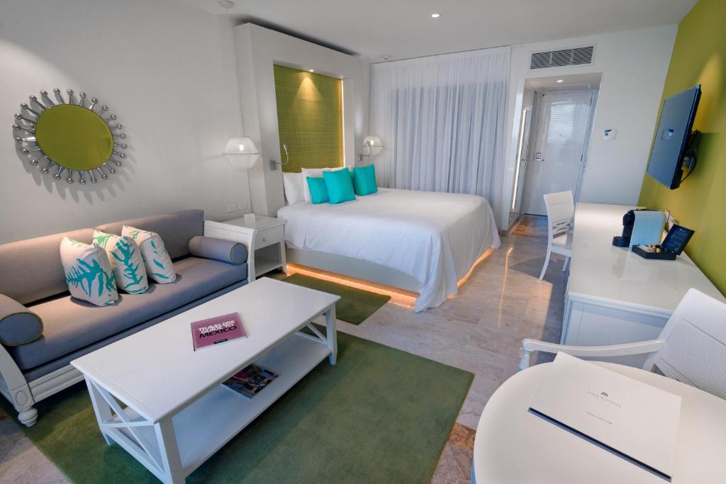 a hotel room with a bed and a couch at Paradisus Cancun All Inclusive in Cancún