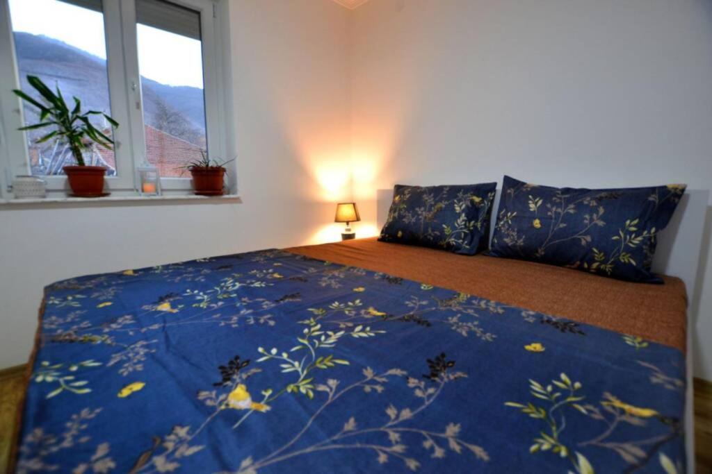 a bedroom with a bed with a blue blanket with flowers on it at View Apartments Belasica in Mokrievo