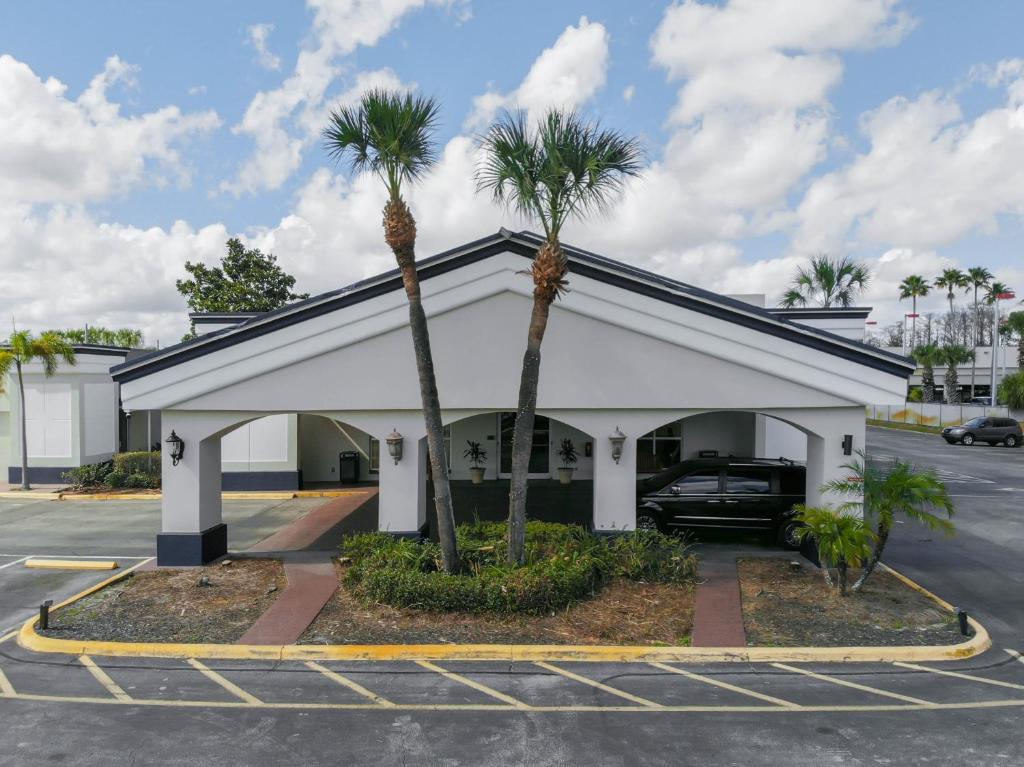 a parking lot with two palm trees in front of a building at Stayable Orlando at Florida Mall in Orlando