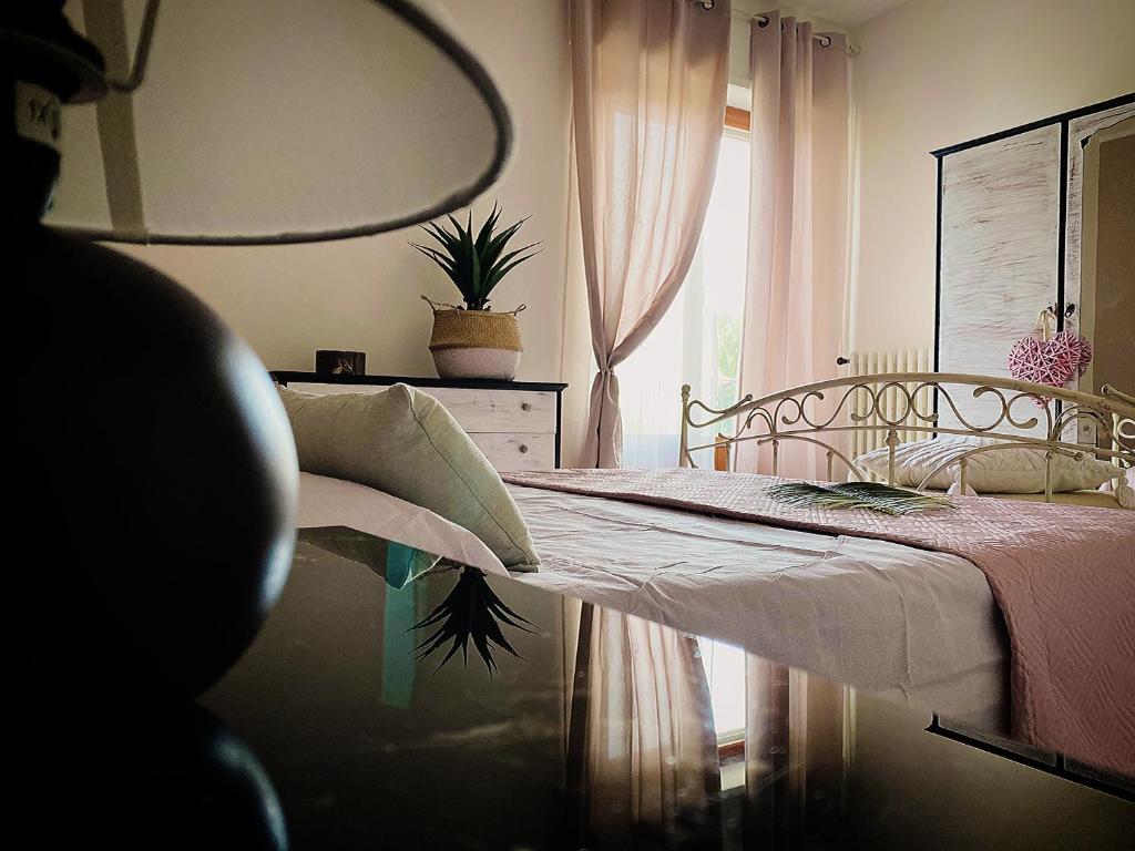 Schlafzimmer mit einem Bett, einem Fenster und einem Spiegel in der Unterkunft La Marinella in Massignano