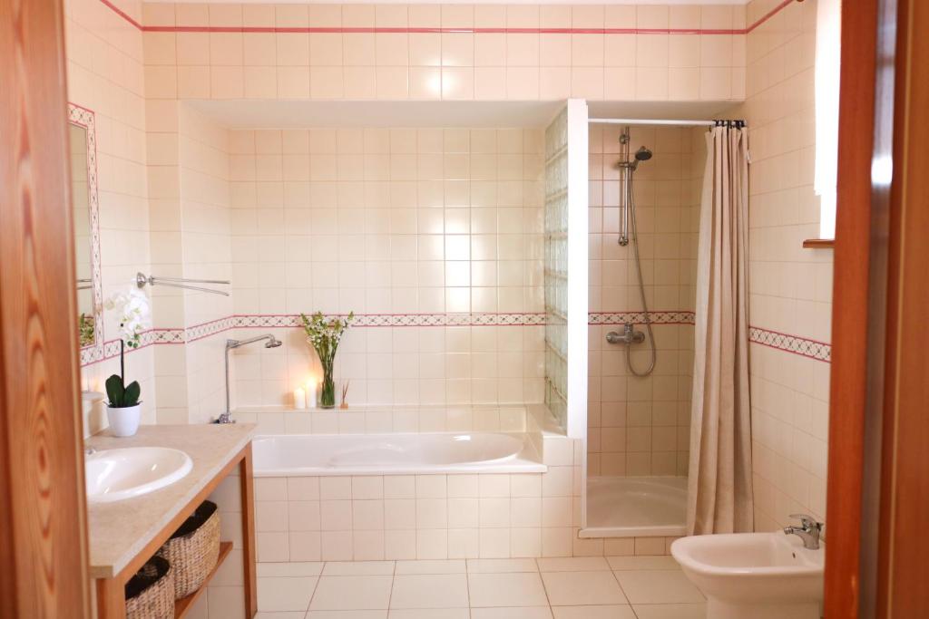 a bathroom with a tub and a sink and a toilet at Quinta Amarela - B&B in Nazaré