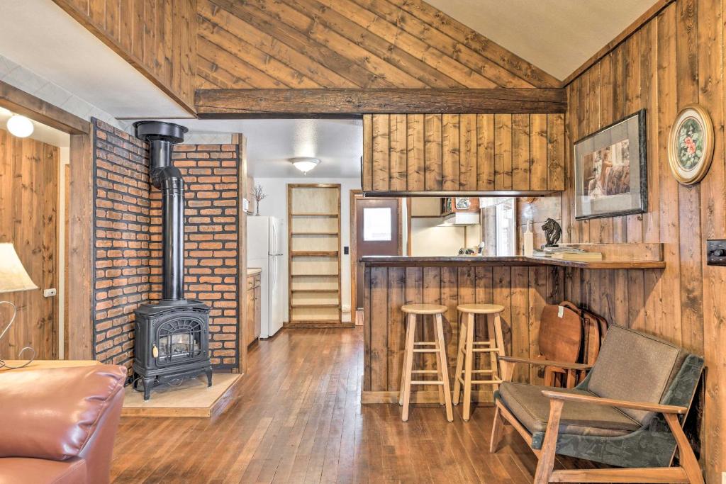 a living room with a fireplace and a stove at Cozy Log Cabin Escape In the Heart of Creede! in Creede