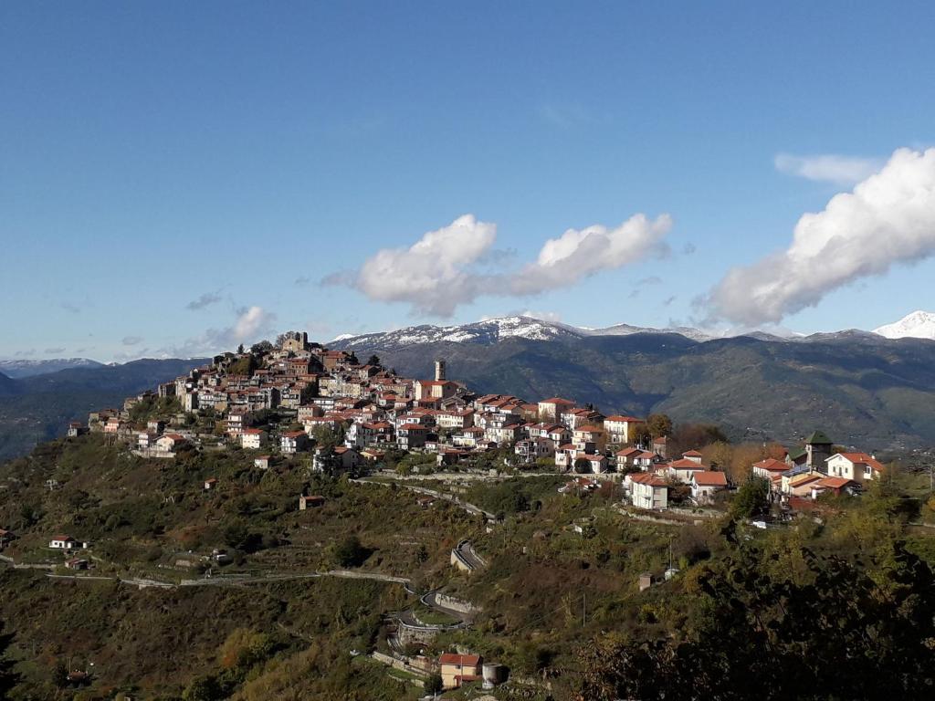 a town on top of a hill with snow covered mountains at Casa Emanuela 1 in Baiardo