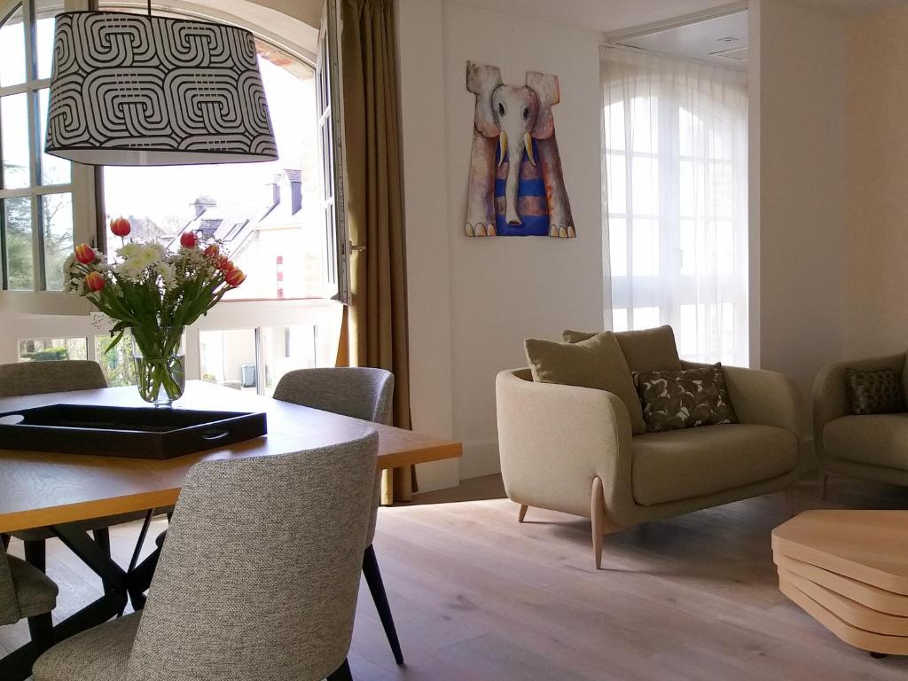 a living room with a table and a dining room at Hôtel Ginkgo - SPA Biloba in Quimper