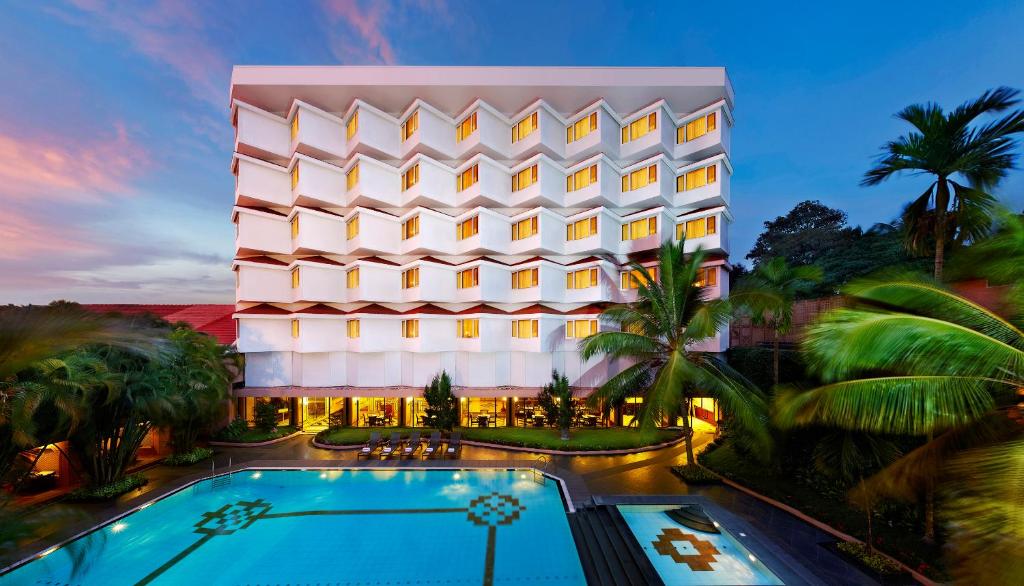 un hotel con piscina frente a un edificio en The Gateway Hotel Beach Road, Calicut en Kozhikode