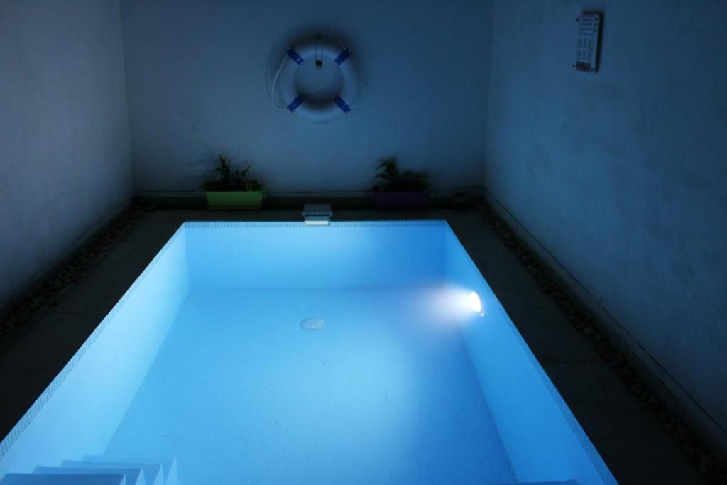 - une piscine avec des lumières bleues dans une chambre dans l'établissement Il-Qastna Holiday House, à Żejtun