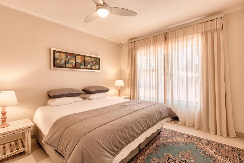 a bedroom with a large bed and a window at Perlemoen Retreat in Herolds Bay