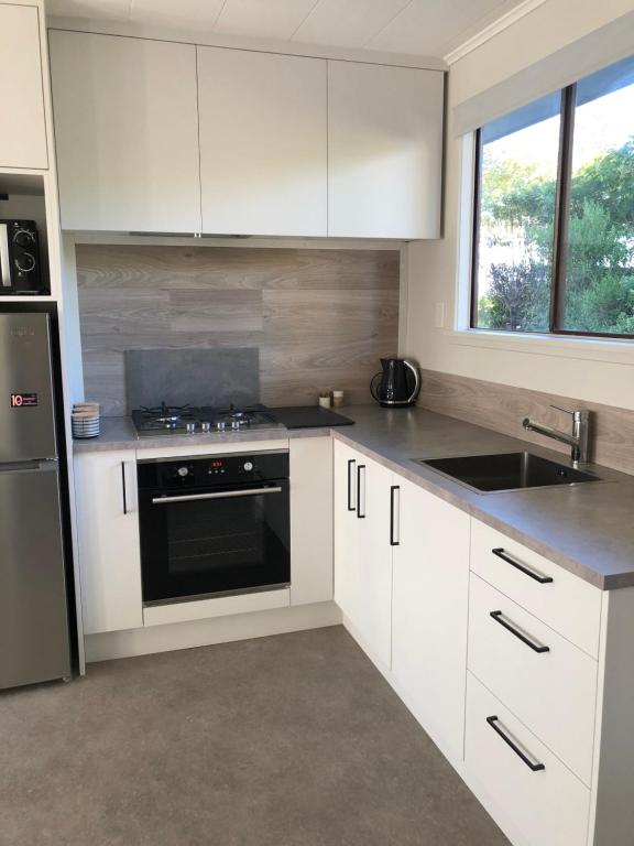 a kitchen with white cabinets and a stove top oven at #5 on Blenheim St in Renwick