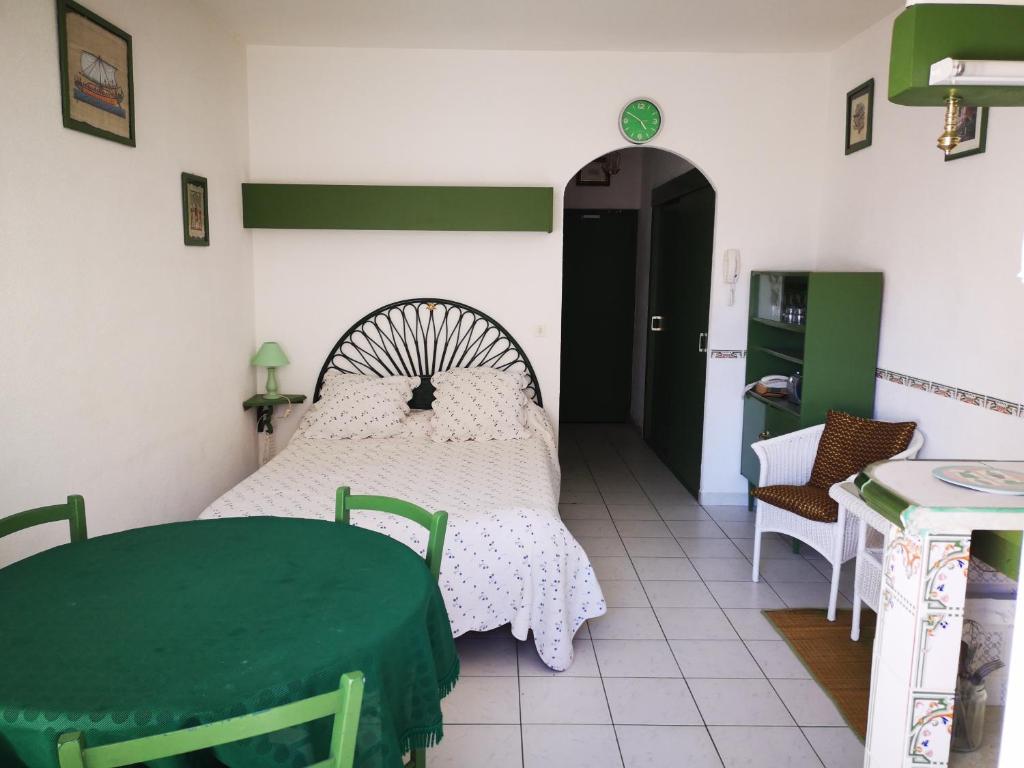 a bedroom with a bed with a green table and chairs at Les Thermes de Vernet-les-bains in Vernet-les-Bains