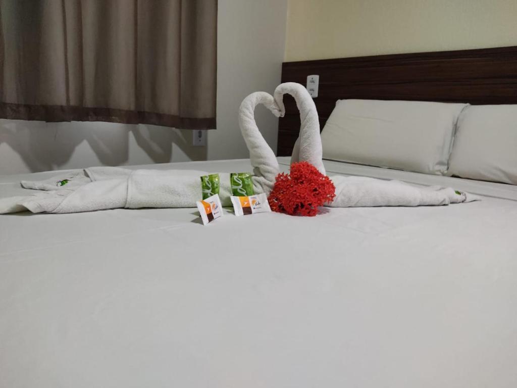 dois cisnes feitos de toalhas numa cama em Pousada Mandacaru em Maceió