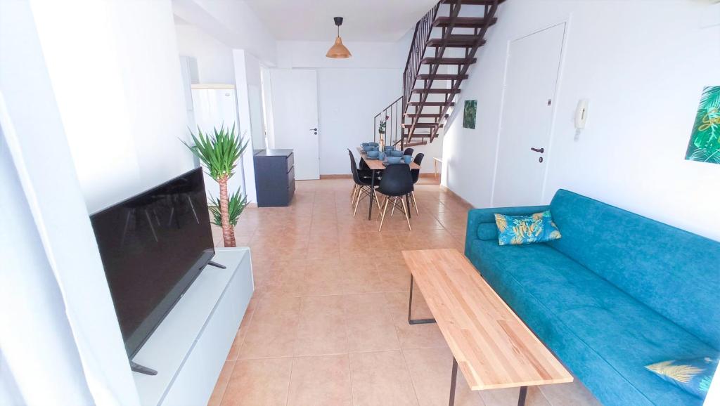 a living room with a blue couch and a table at Luxury Maisonette Apartment - EA VIEW, GYM- 5 Min from Beach in Larnaka
