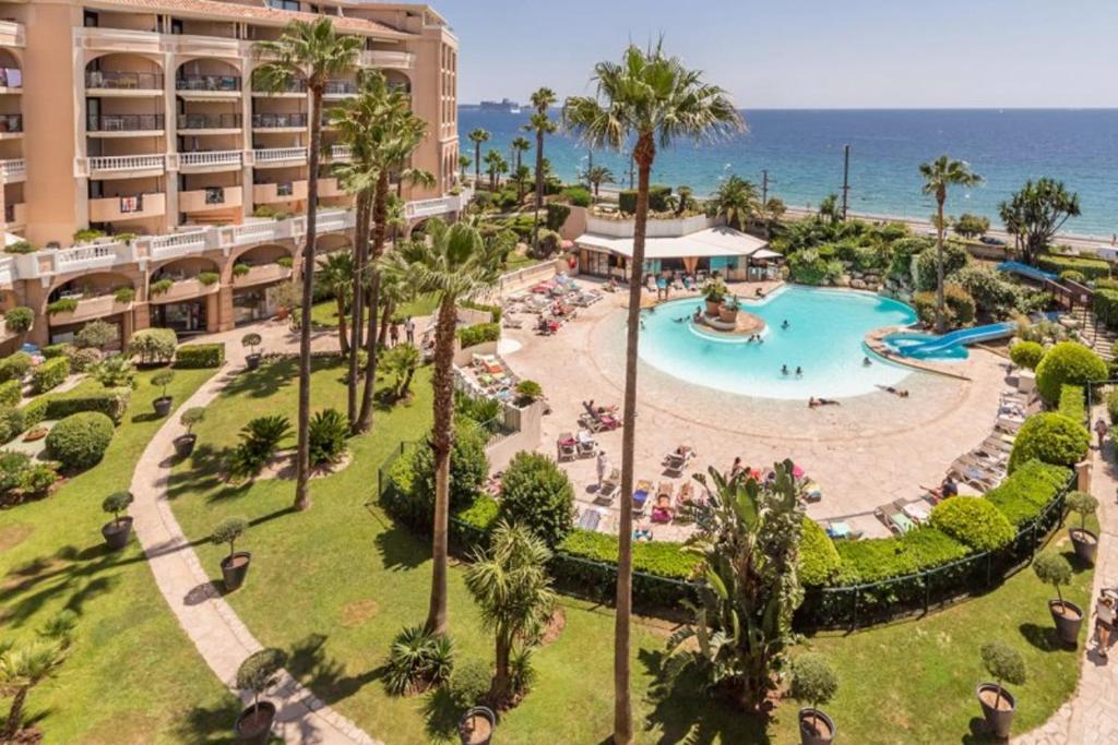 une vue aérienne d'un complexe hôtelier avec piscine et l'océan dans l'établissement Nice Apartment With Sea View And Balcony, à Cannes
