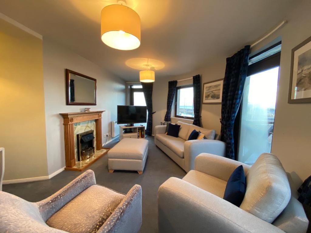 a living room with couches and a fireplace at Harbour View & Beach 50m from doorstep! in Nairn