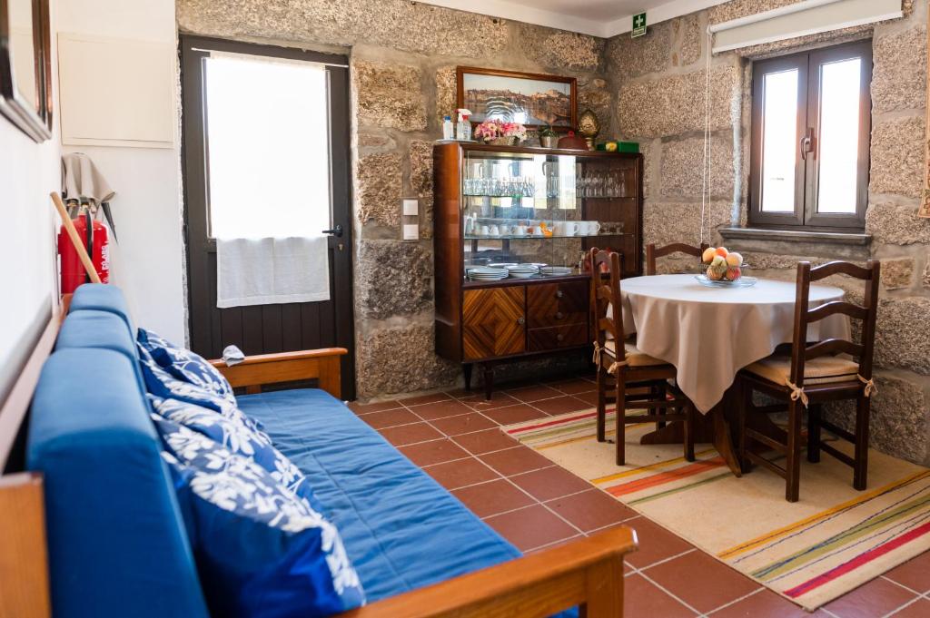 un soggiorno con tavolo e divano blu di Partezins 2 a Castelo de Paiva