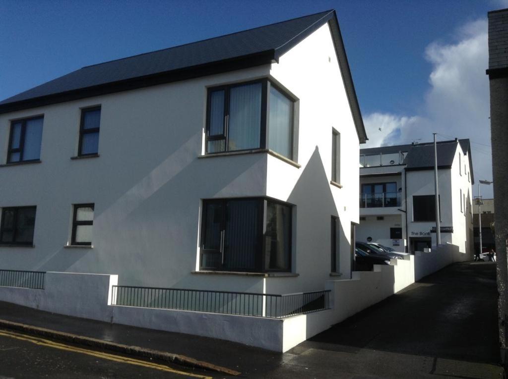 a white house with a black roof at Mourneview Loft - Luxury Apartment in Newcastle