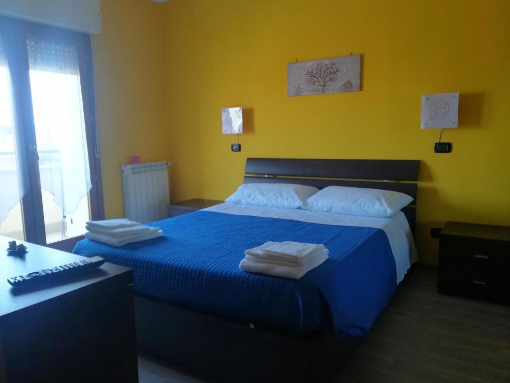 Romanina Appartamento Giuland في روما: غرفة نوم بسرير ازرق عليها مناشف