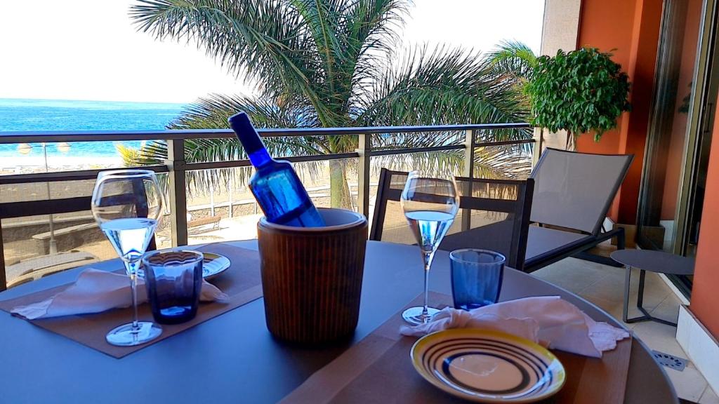 einen Tisch mit einer Flasche Wein und zwei Gläsern in der Unterkunft Apartamento El Atardecer in Tazacorte