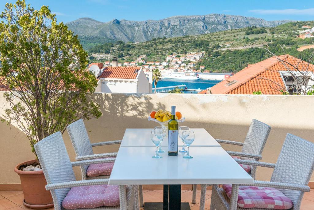 una mesa blanca con copas de vino en el balcón en Apartment Adria en Dubrovnik
