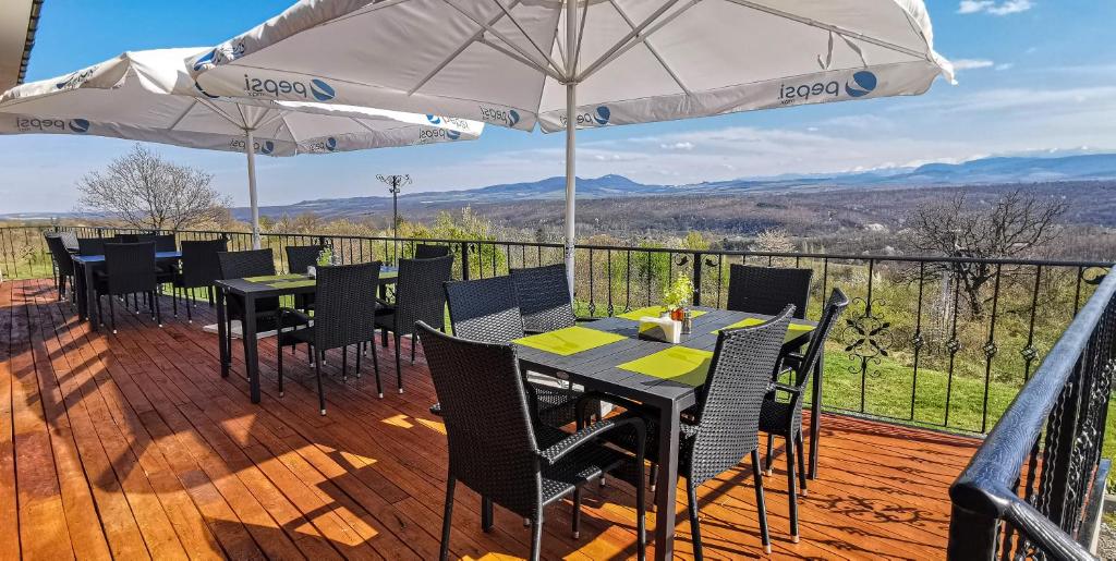 a patio with tables and umbrellas on a deck at Complex Magura in Rabisha