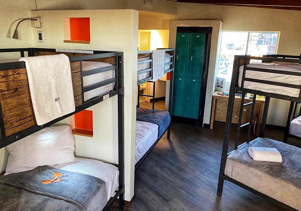 a room with three bunk beds and a doorway at Paris Hostel in Tijuana