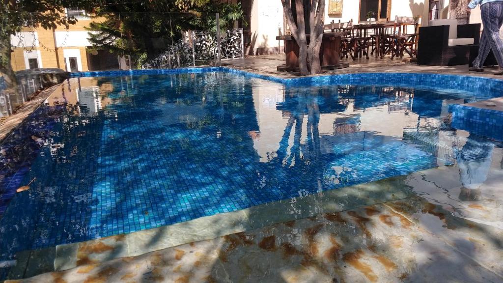 a swimming pool with blue water in a building at Bella Tierra Hotel Boutique in Tibasosa