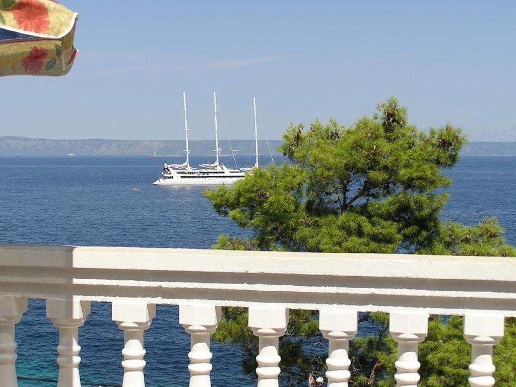 a boat in the water with a white railing at Apartments Dijana - 20m from the sea in Prigradica