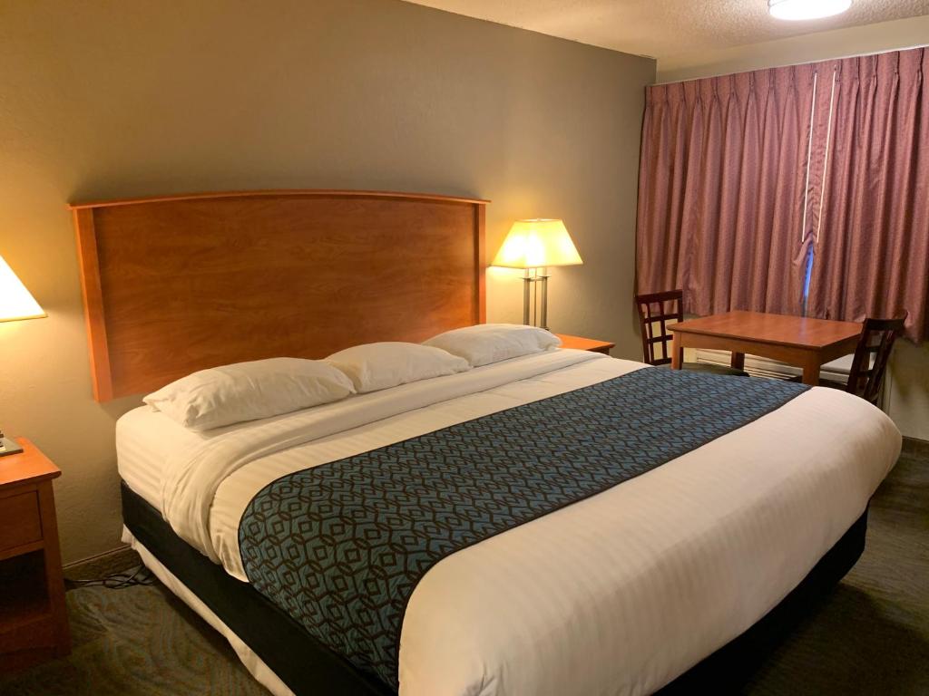 una habitación de hotel con una cama grande y una mesa en Sunset Inn - John Day, en John Day