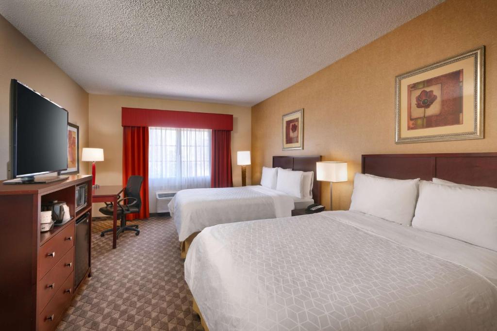 a hotel room with two beds and a flat screen tv at Best Western Downtown Phoenix in Phoenix