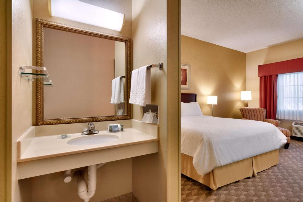 a hotel room with a bed and a sink and a mirror at Best Western Downtown Phoenix in Phoenix