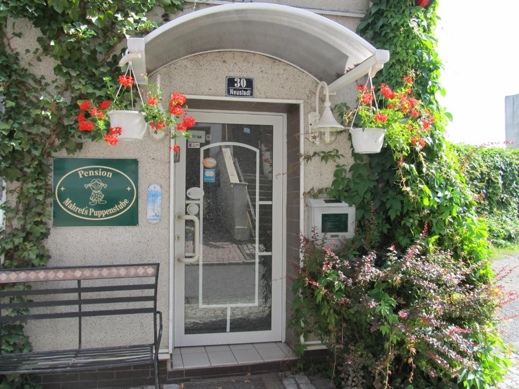 una entrada a un edificio con una puerta con flores en Pension Mahrets Puppenstube, en Eisenach