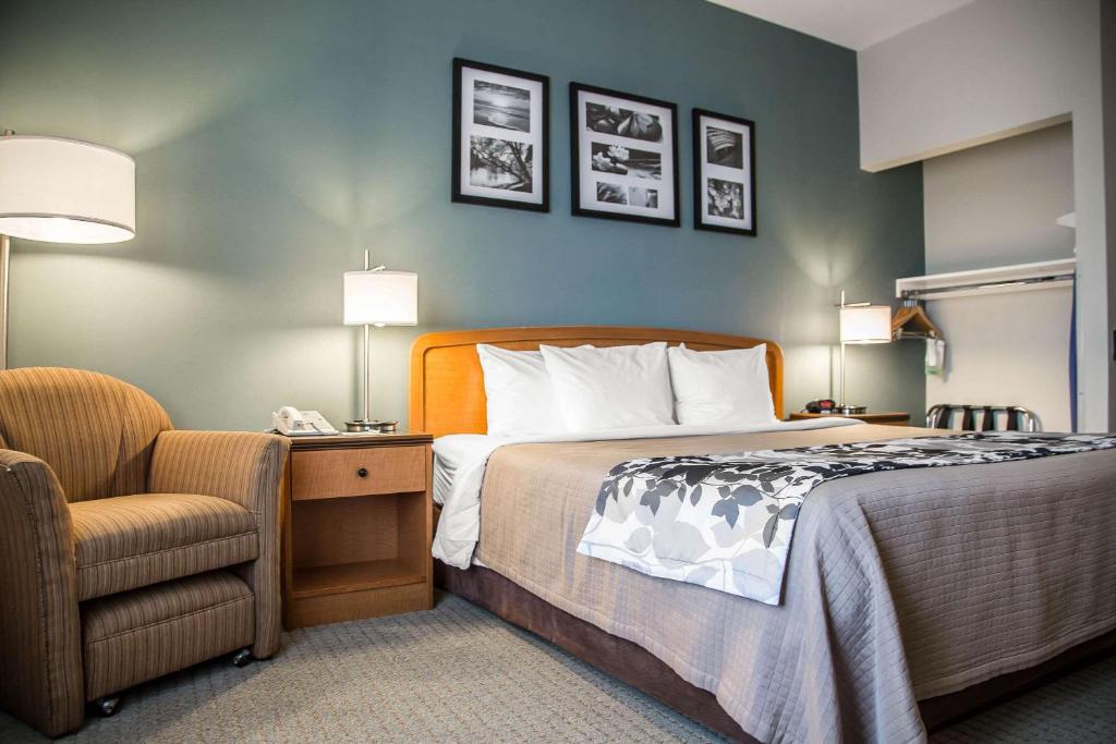 ein Hotelzimmer mit einem Bett und einem Stuhl in der Unterkunft Sleep Inn and Suites Davenport in Bettendorf
