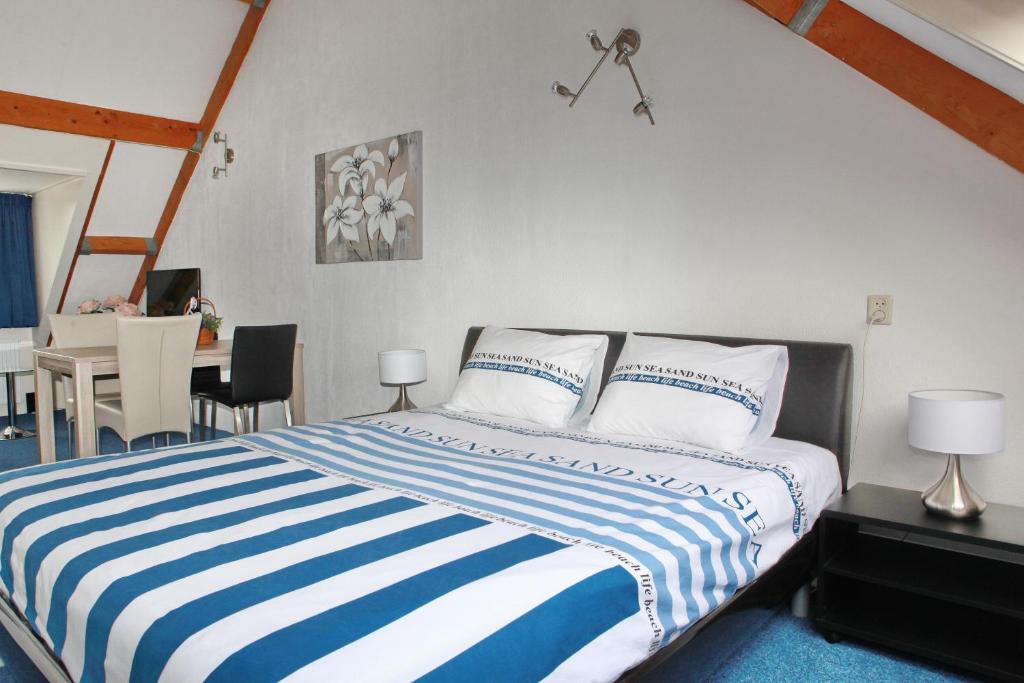 Teska Bed & Breakfast في فينندال: غرفة نوم بسرير وبطانية مخططة باللون الأزرق والأبيض