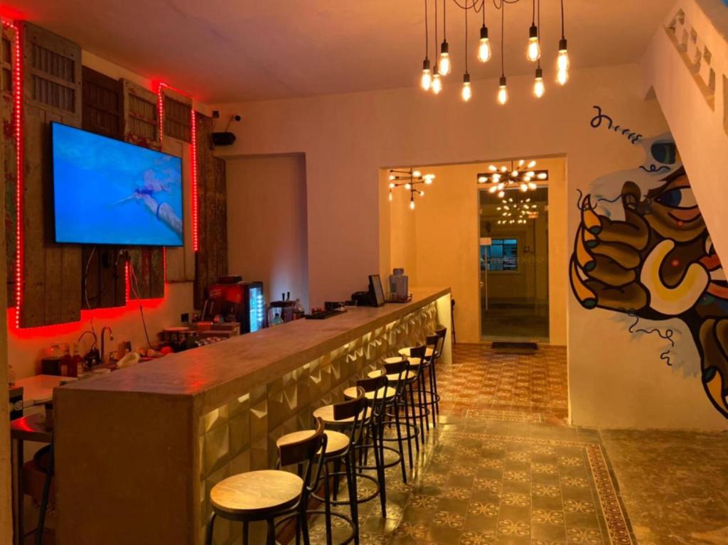 um bar num restaurante com bancos e uma televisão em Hotel Unknown em Mérida
