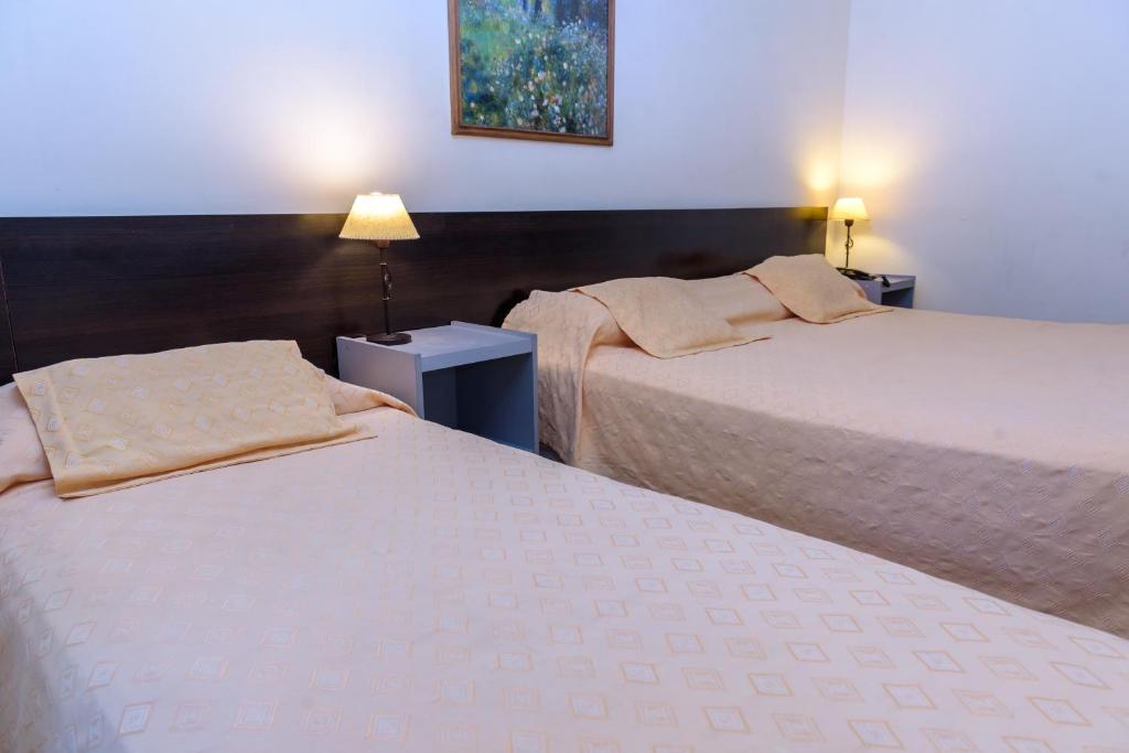 聖胡安的住宿－Hotel Cerro Blanco，配有2盏灯的酒店客房的2张床