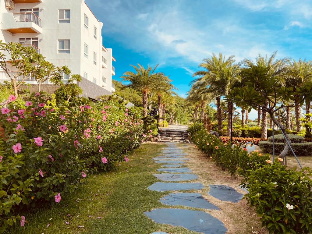 a walkway in front of a building with flowers at Bay Forest Boutique B&B in Hengchun