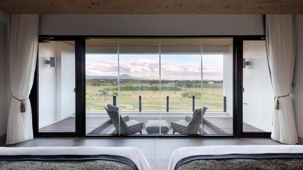 a room with a large window with a table and chairs at SkyeBay Club in Hengchun