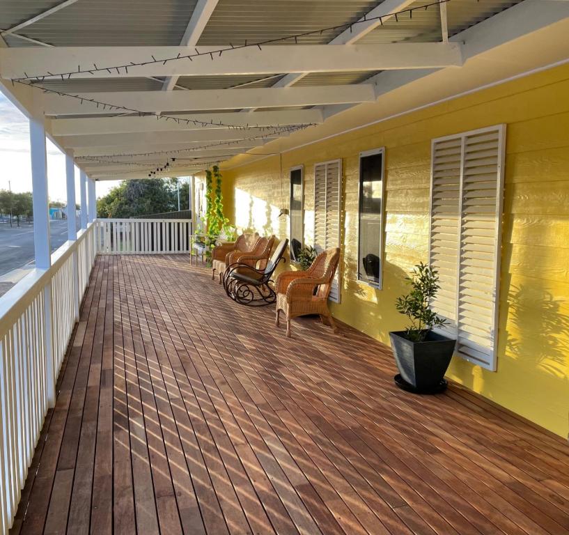 une terrasse couverte avec des bancs et des chaises sur une maison jaune dans l'établissement KI Dragonfly Guesthouse, à Kingscote