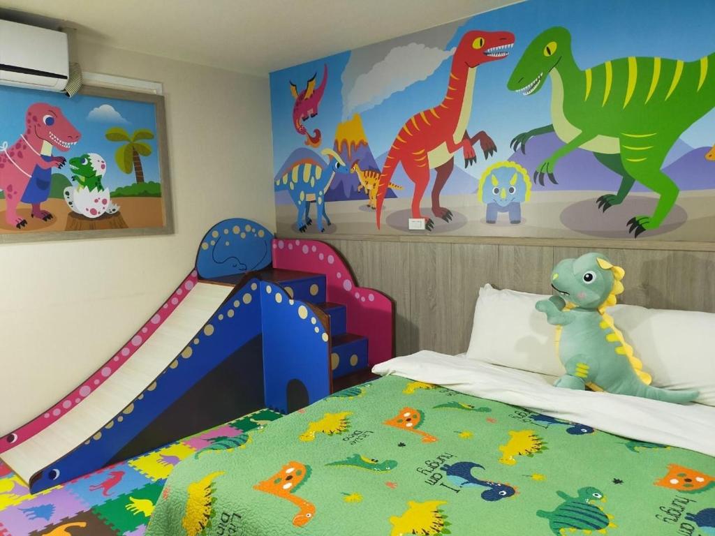 a childs bedroom with dinosaurs on the wall at Happy Castle Cottage in Hualien City
